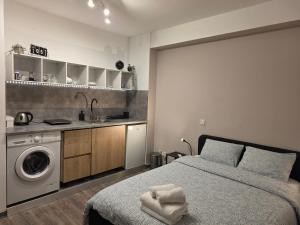 a bedroom with a bed and a sink and a washing machine at Beach apartment's in Limassol