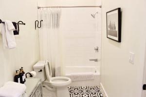 a white bathroom with a toilet and a shower at Lodge 2 on the Mason TX square in Mason