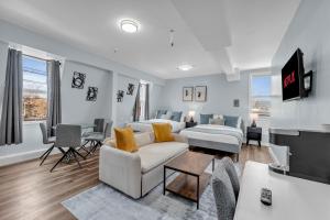 a living room with a couch and a room with a tv at Guestic Hotel at Queen West in Toronto