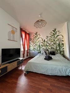 a bedroom with a large bed and a television at Disneyland Family Studio in Magny-le-Hongre