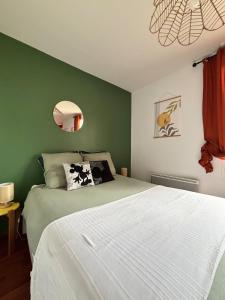 a bedroom with a white bed with a green wall at Disneyland Family Studio in Magny-le-Hongre +13 photos