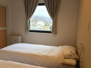 Postel nebo postele na pokoji v ubytování Uchimaru Hakuba