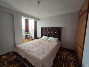 a bedroom with a large bed with two pillows on it at Candela Apartment PUNO in Puno