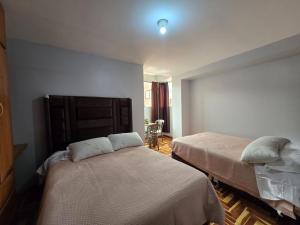 a bedroom with two beds in a room at Candela Apartment PUNO in Puno