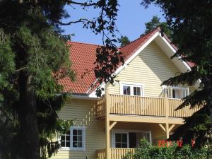 uma casa com um deque e um telhado em Haus Stoertebeker Appartements - Hotel Garni, Seebad Lubmin em Lubmin