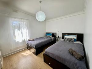 a bedroom with two beds and a window at Clare Cottage on Wendouree in Clare