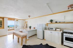 a kitchen with a white refrigerator and a table at Surfers Bay in Christ Church