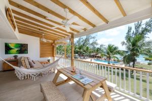 a porch with a hammock and a view of the ocean at Surfers Bay in Christ Church