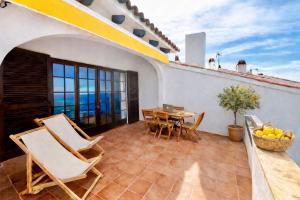 a patio with a table and chairs on a balcony at EcoHome Menorca in Cala en Porter