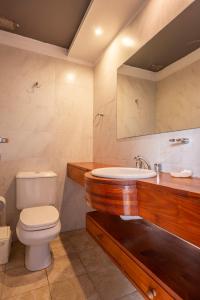 a bathroom with a toilet and a sink at Cabañas Cambados in Villa Gesell