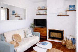 a living room with a couch and a fireplace at EcoHome Menorca in Cala en Porter