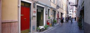 a group of people walking down a street with buildings at PIO Rooms b&b Parma in Parma