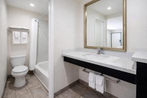 a bathroom with a sink and a toilet and a mirror at Super 8 by Wyndham Bakersfield CA Near Airport in Bakersfield +31 photos
