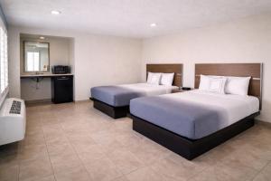a hotel room with two beds and a bathroom at Super 8 by Wyndham Bakersfield CA Near Airport in Bakersfield