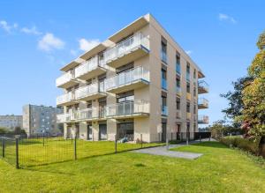 an apartment building with a lawn in front of it at MDM Apartments in Gdańsk