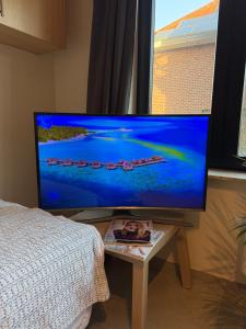 a large flat screen tv on a table in a bedroom at Studio in Leuven in Leuven