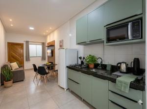 a kitchen with a white refrigerator and a table at 3 Frontiers Landmark House in Foz do Iguaçu