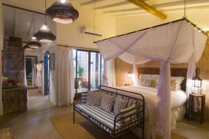 a bedroom with a canopy bed and a couch at Hotel Boutique Perainda in Trancoso +164 photos