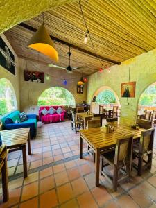 a living room with tables and chairs and a couch at Finca Carpe Diem Ecolodge in Minca