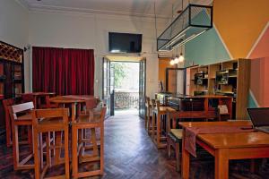 a restaurant with wooden tables and chairs and a television at Colors House in Sucre