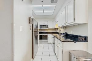 a kitchen with white cabinets and a refrigerator at Phoenix I 1142 in Orange Beach