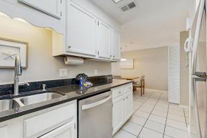 a kitchen with white cabinets and a sink at Phoenix I 1142 in Orange Beach +23 photos