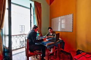 two people sitting at a table with a laptop at Colors House in Sucre