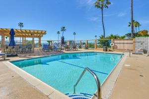 a swimming pool at a resort with tables and chairs at Beachfront, Amazing 180-Degree View in Oceanside