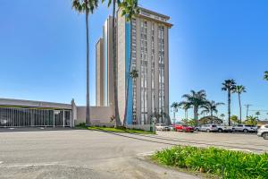 a large building with palm trees and a parking lot at Beachfront, Amazing 180-Degree View in Oceanside