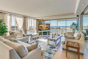 a living room with white furniture and large windows at Beachfront, Amazing 180-Degree View in Oceanside