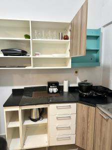 a kitchen with white cabinets and a black counter top at CDE House in Ciudad del Este