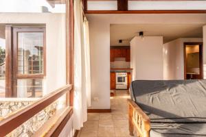 a room with a balcony with a bed and a kitchen at Cabañas Cambados in Villa Gesell