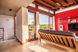 a living room with a bench and a red wall at Cabañas Cambados in Villa Gesell