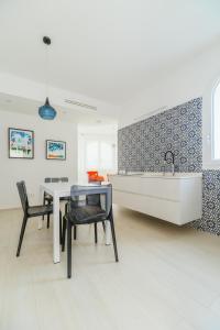 a kitchen with a sink and a table and chairs at Azuleyos Garden & Pool fronte mare in Marcelli