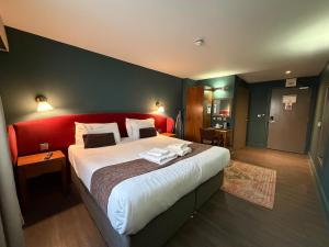a bedroom with a large bed with a red headboard at HNFC Stays - Harmony Accommodation in Elswick