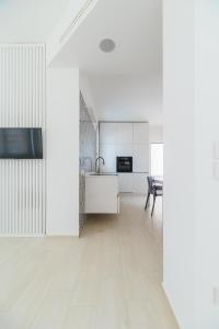 an open kitchen and dining room with white cabinets at Azuleyos Garden & Pool fronte mare in Marcelli +16 photos