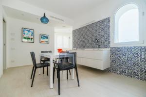 a kitchen with a table and chairs and a sink at Azuleyos Garden & Pool fronte mare in Marcelli