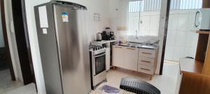 a small kitchen with a stainless steel refrigerator at Suíte aconchego in Guaratuba