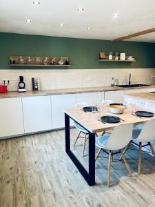 a kitchen with a wooden table and chairs at Maison avec Jacuzzi - Europa-Park in Obenheim +7 photos