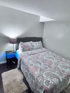 a bedroom with a bed and a table with a lamp at Bernie's Basement in Milton