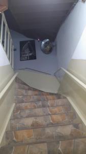 a stairway with a stone floor and a clock on the wall at Hotel Baguari in São Paulo +2 photos