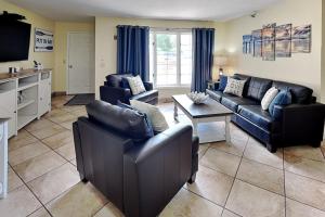 a living room with leather couches and a tv at Put-in-Bay Poolview Condo #2 in Put-in-Bay +40 photos