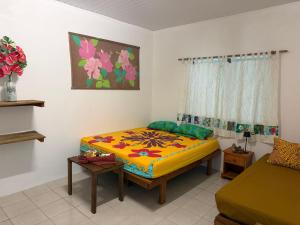 a bedroom with a bed and a couch in it at Le KAHAIA Rangiroa Tiputa in Rangiroa
