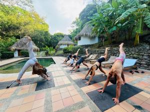 a group of people doing yoga by a pool at Finca Carpe Diem Ecolodge in Minca