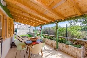 a patio with a table and chairs and a wooden ceiling at House Ara in Grohote