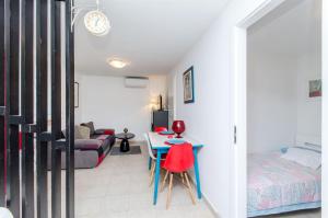 a room with a bed and a table with red chairs at House Ara in Grohote +12 photos