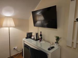 a room with a desk with a tv on the wall at Silent Retreat, Boutique Suite inside Monastery in Suceava