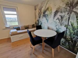 a living room with a table and chairs and a couch at Wohnung Werratal Blick in Dankmarshausen