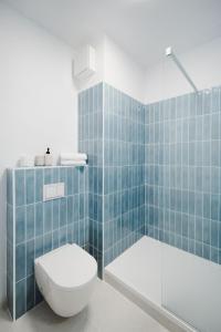 a blue tiled bathroom with a toilet and a shower at Castle view Vinetto apartment with free parking in Trenčín +11 photos