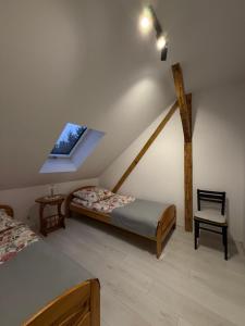 a attic bedroom with two beds and a window at Apartament u Buki Zator, Skawina, Kraków in Pozowice